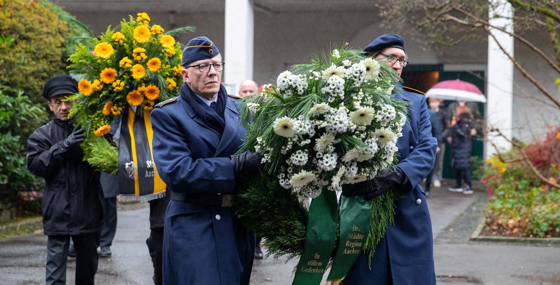 Soldaten tragen gemeinsam einen Gedenkkranz