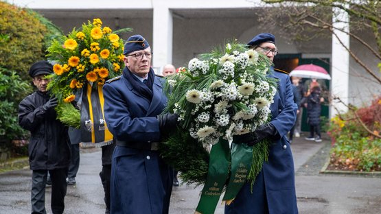 Soldaten tragen gemeinsam einen Gedenkkranz