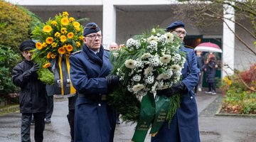 Soldaten tragen gemeinsam einen Gedenkkranz