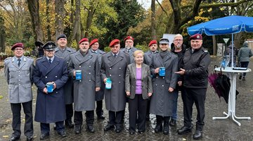 Auf dem Gruppen Foto sieht man zwölf Personen; von denen vier eine Sammeldose in der Hand haben 