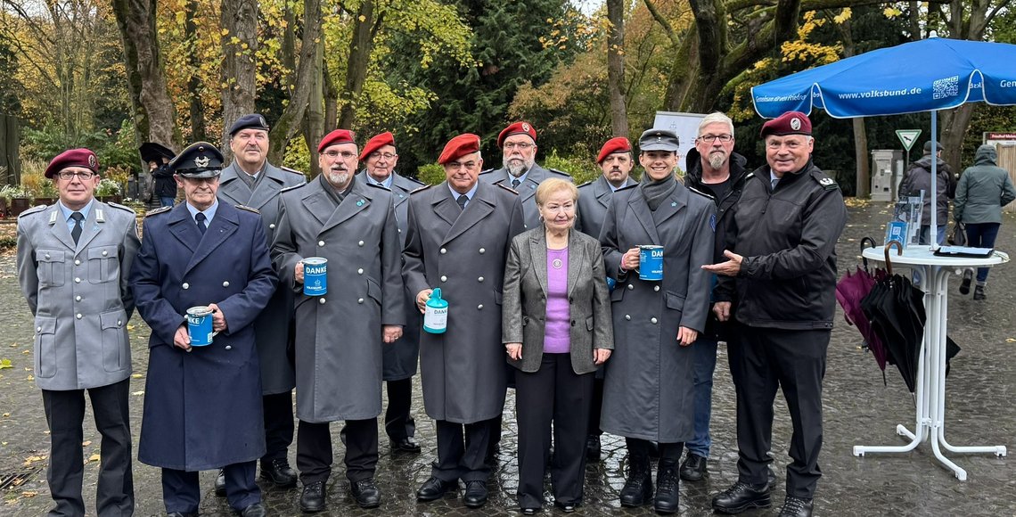 Auf dem Gruppen Foto sieht man zwölf Personen; von denen vier eine Sammeldose in der Hand haben 